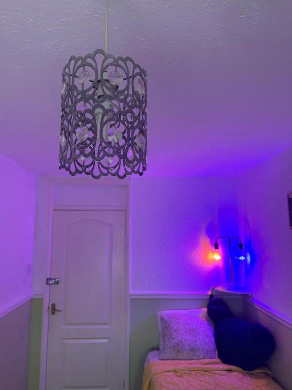 罗金厄姆LN host的紫色的客房配有一张床和吊灯