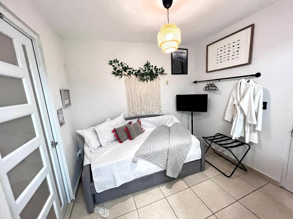 圣胡安Villa 5 Min From San Juan Airport and Isla Verde Beach Best Location & Pool & Jacuzzi & YOUTUBE VIDEO Available的一间卧室配有带白色床单和枕头的床。