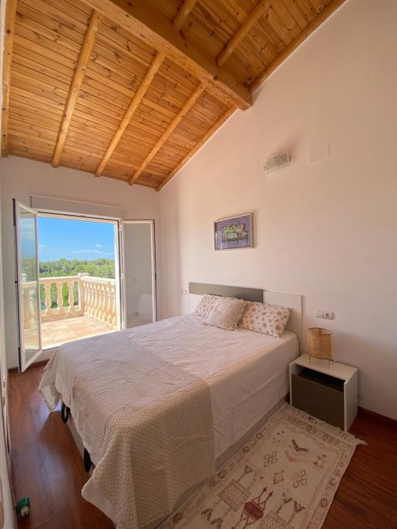 拉梅特拉·德·玛尔Villa Palmera的一间卧室设有一张大床和一个大窗户