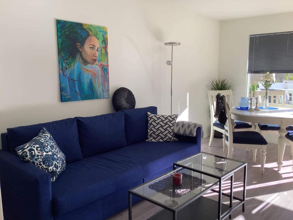 希恩SylviaBo的客厅配有蓝色的沙发和桌子