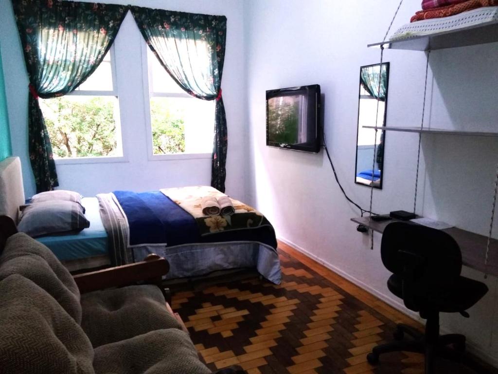 阿雷格里港Sobrado Tranquilo Centro的一间卧室配有一张床、一张书桌和一个窗户。