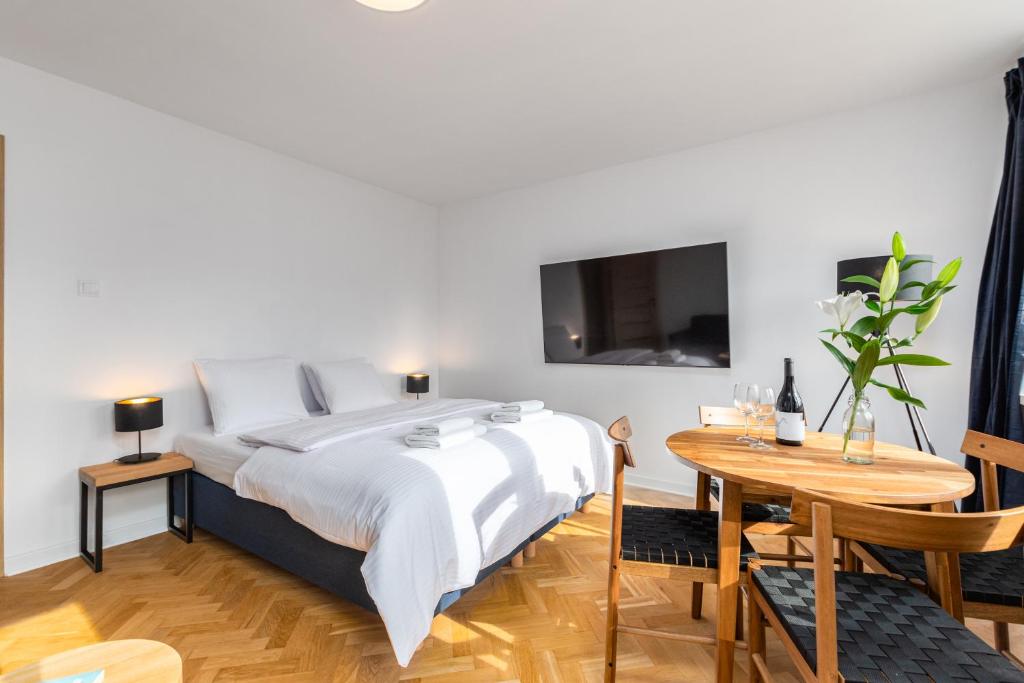 华沙Apartament Jasna by Your Freedom的一间卧室配有一张床、一张桌子和一台电视。