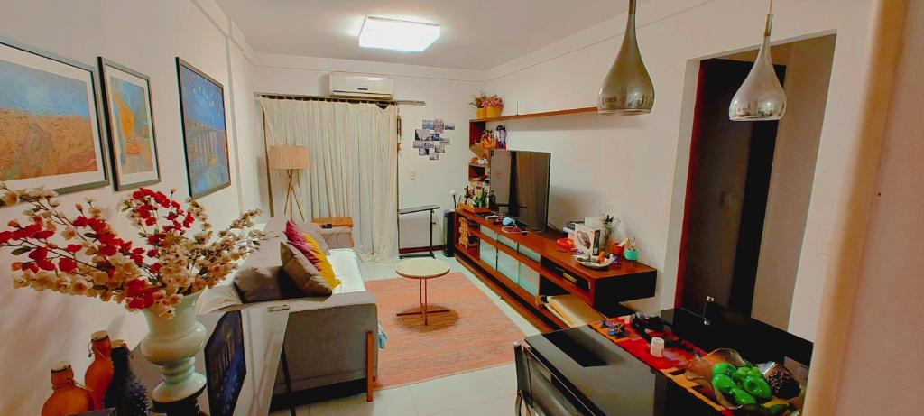 维多利亚Quarto e banheiro privativos com garagem fechada em apartamento aconchegante em Jardim da Penha的客厅配有沙发和桌子。