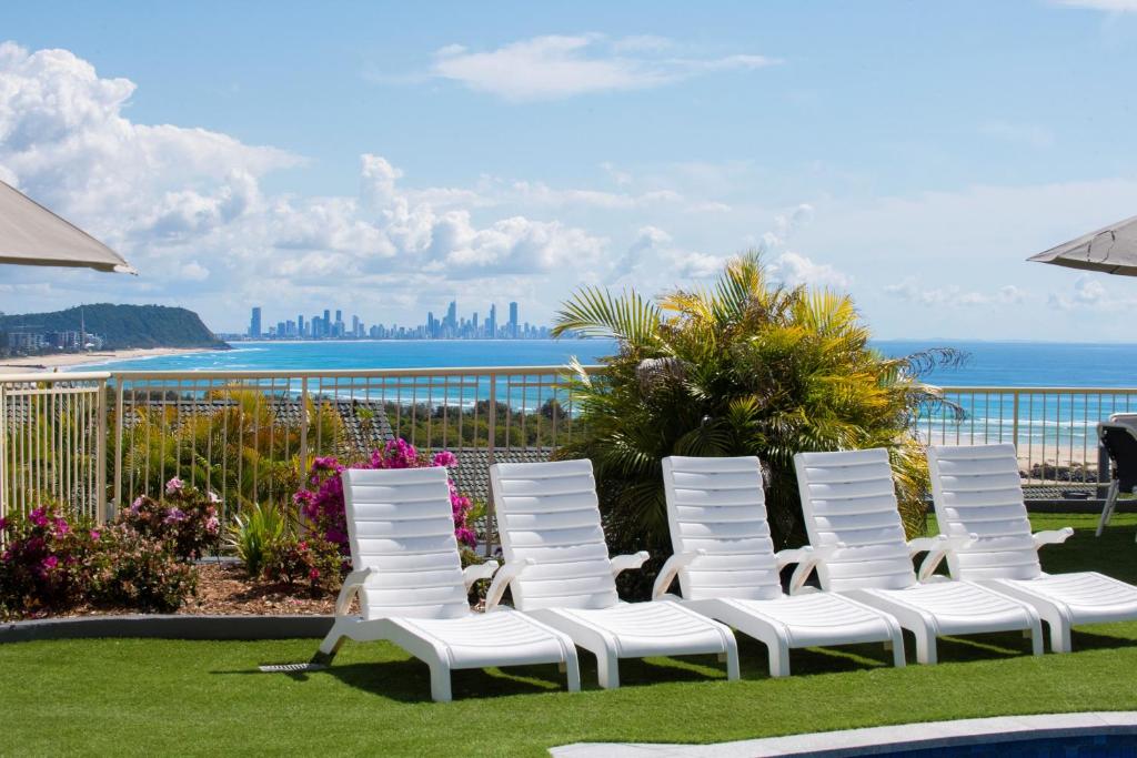 黄金海岸可兰宾海滩山脉公寓酒店的一组坐在海边的白色椅子