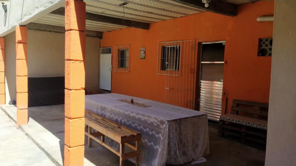 SaubaraCasa de temporada em Cabuçu的一间设有橙色墙壁、桌子和长凳的房间