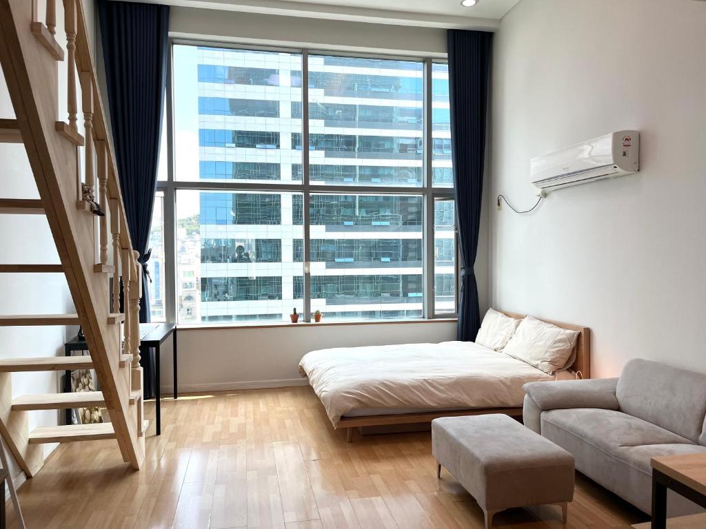 首尔Hongdae Station loft apartment的客厅设有床和大窗户