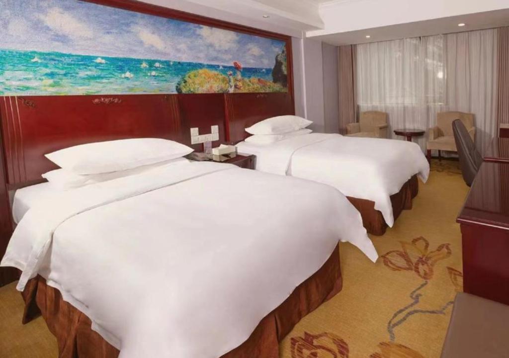 上海维也纳国际酒店(上海交大沪闵路店)的酒店客房设有两张床,墙上挂有绘画作品