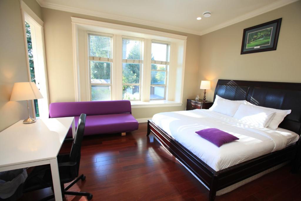 伯纳比Vancouver Metrotown Guest House 8 mins walk to Sky Train的一间卧室配有一张床、一把椅子和窗户。