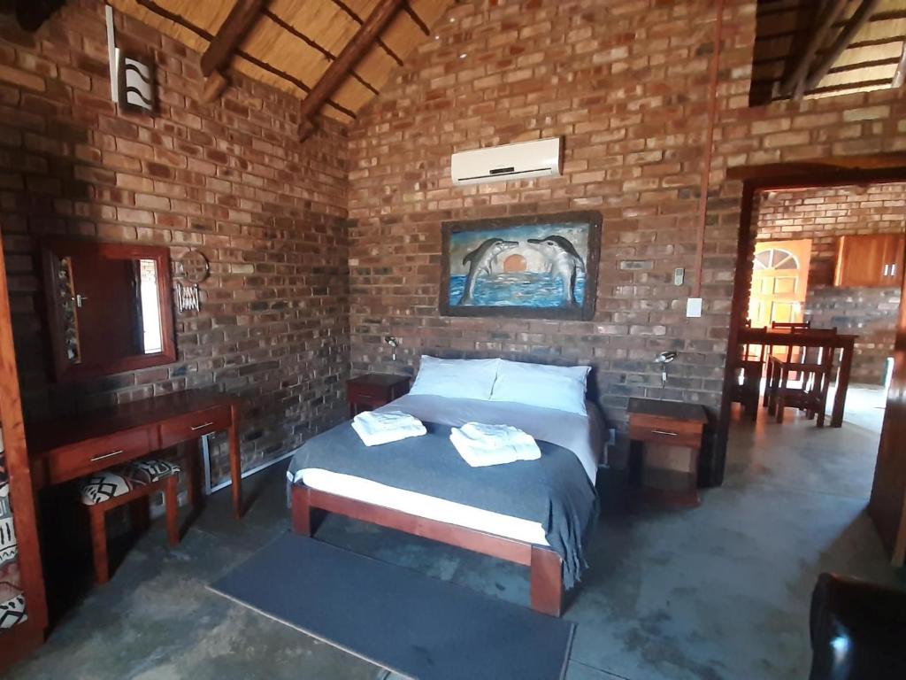 Gobabis西巢小屋旅馆的一间卧室设有一张床和砖墙