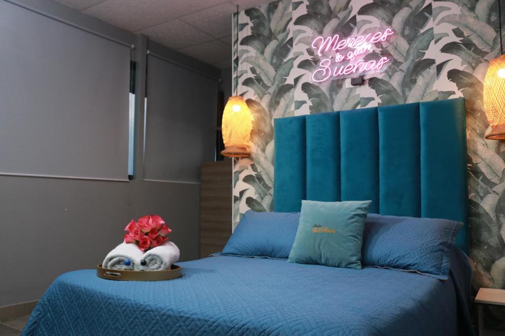瓜亚基尔SUITES FullHouse的卧室配有蓝色的床,墙上有标志