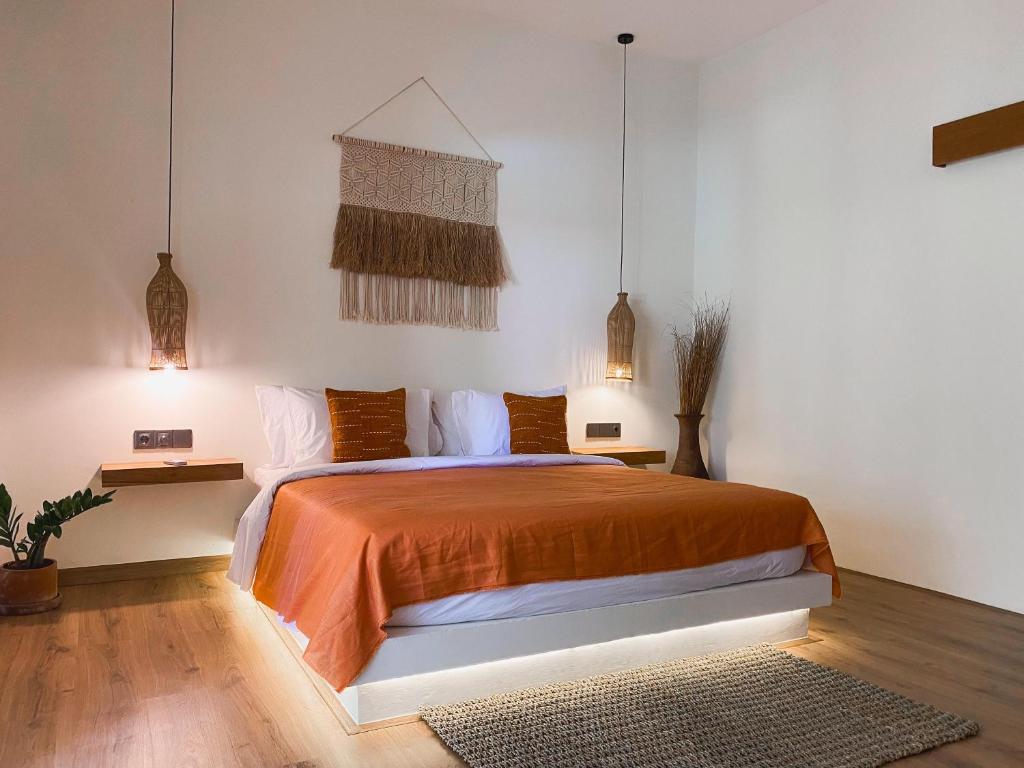 龙目岛库塔Reset Lombok Hotel的一间卧室配有一张带橙色床罩的床
