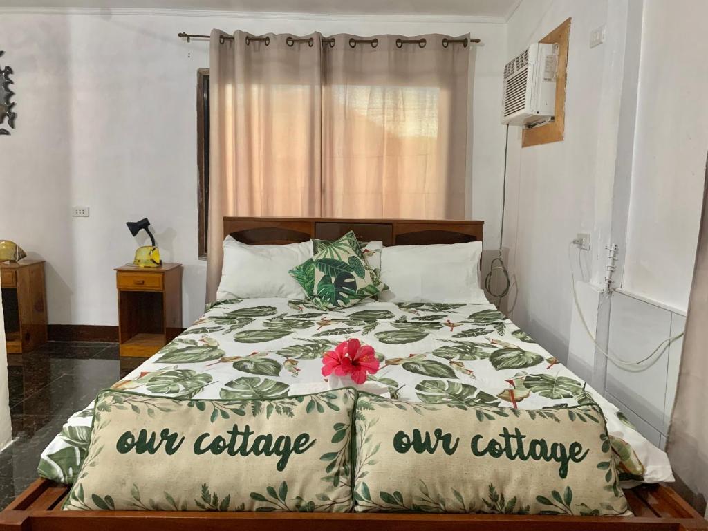 莫阿尔博阿Panagsama Holiday Cottage的一间卧室,配有一张带鲜花的床