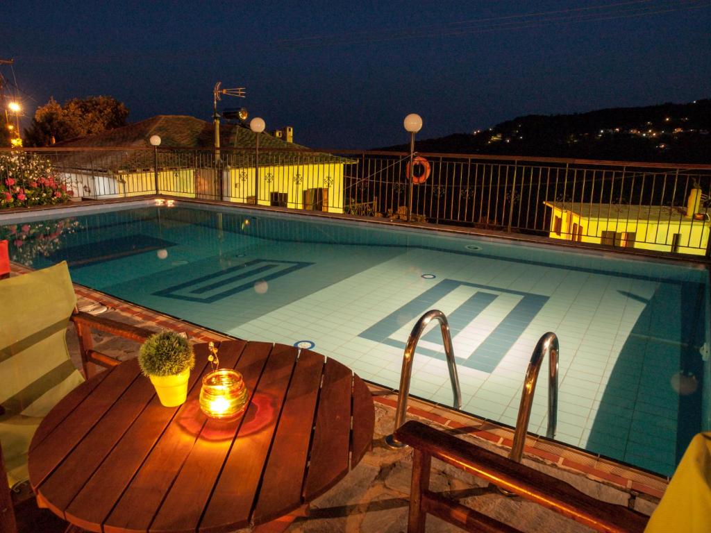 Makrirrákhi阿斯特洛米亚酒店的木制甲板上的带桌子和蜡烛的游泳池