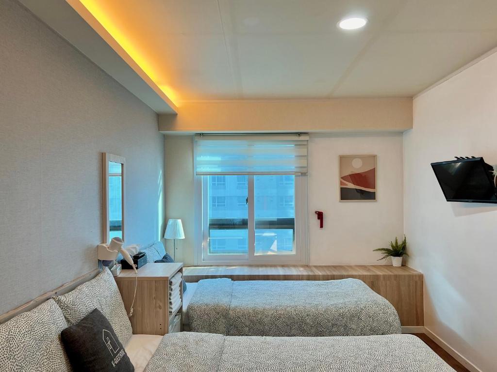 首尔梨大 首爾大旅館的一间卧室设有两张床和窗户。