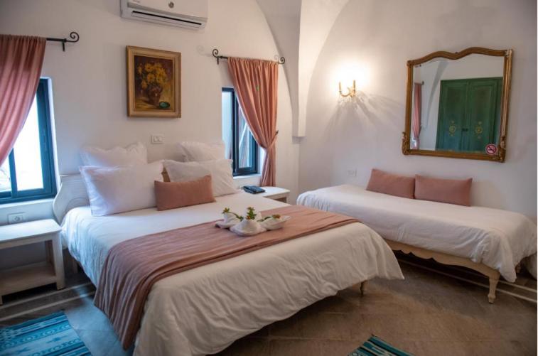 古莱比耶Dar Gino的酒店客房,设有两张床和镜子