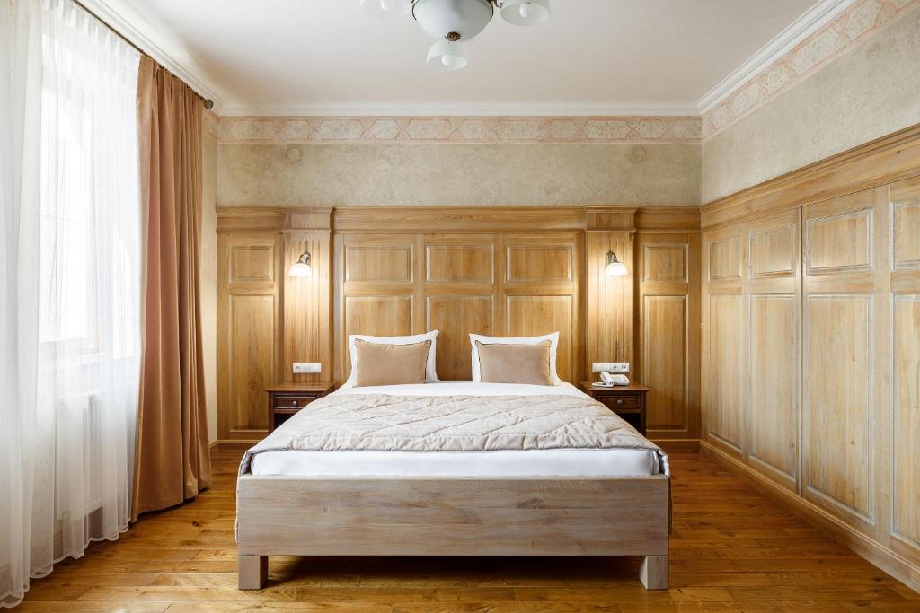 伊万诺-弗兰科夫斯克GANZ HOTEL的一间卧室配有一张带木镶板的大床