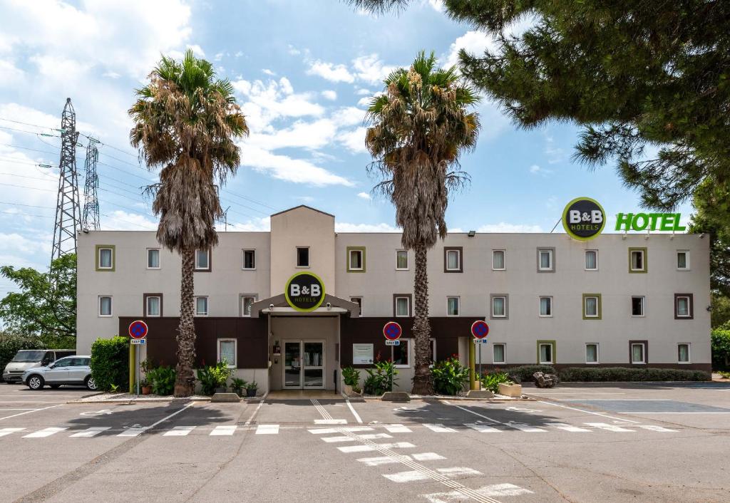 圣让德韦达B&B HOTEL Montpellier 1的前面有棕榈树的酒店