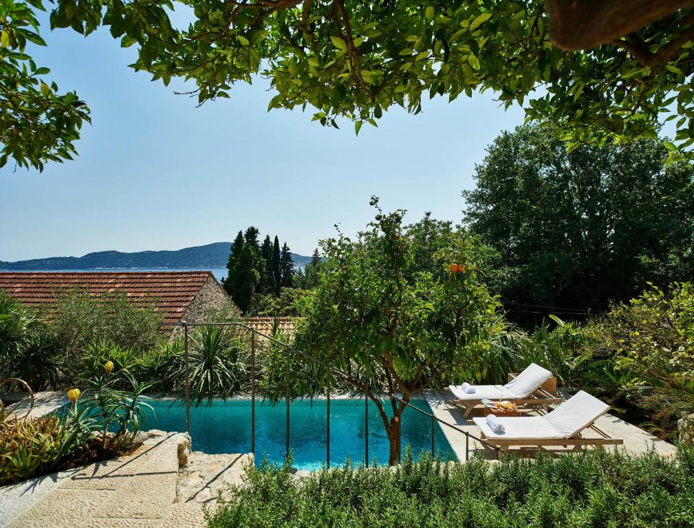 特斯特诺Villa Lemonia的游泳池旁的游泳池配有2把躺椅