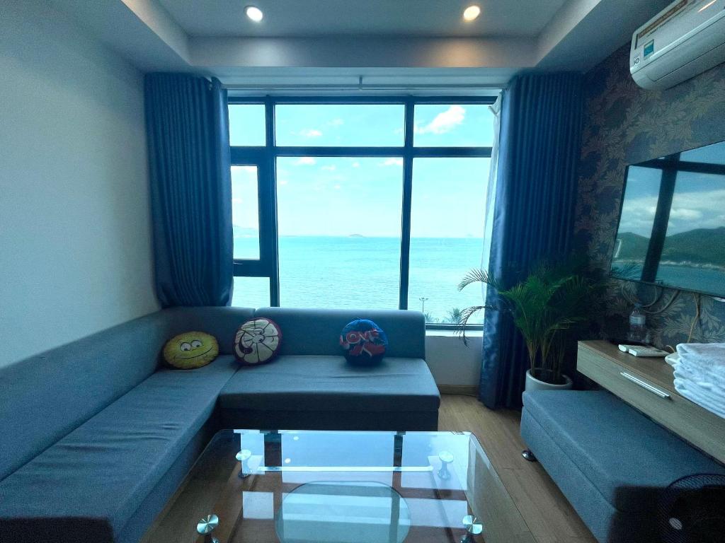 芽庄Mường Thanh Luxury Viễn Triều Apartment的客厅设有蓝色沙发,享有海景