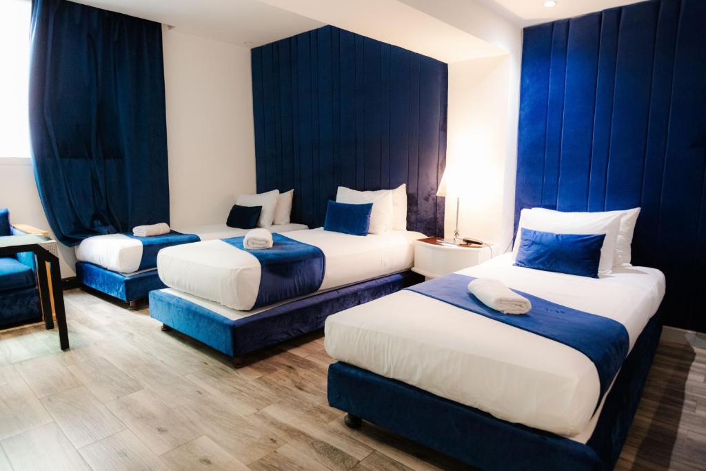 卡萨布兰卡WINDSOR HOTEL CITY CENTER的酒店客房,配有两张带蓝色窗帘的床