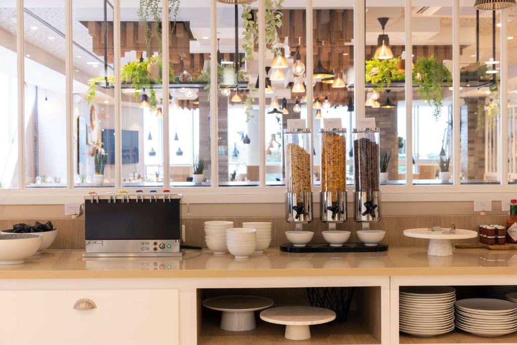 勒阿弗尔Hilton Garden Inn Le Havre Centre的一间设有板子和花瓶的柜台的餐厅