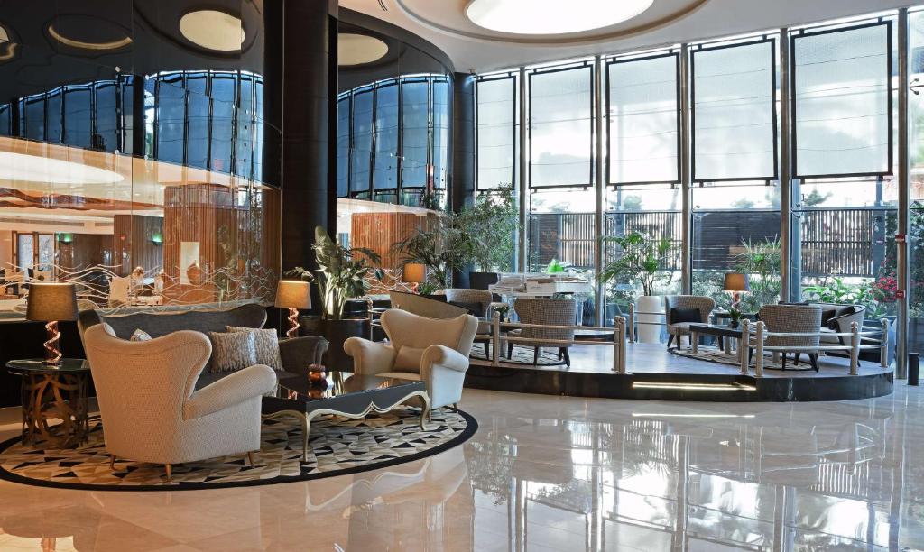 安曼Hilton Amman的大堂设有桌椅和窗户。