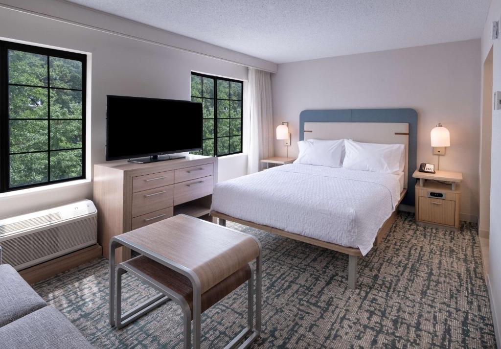 亚特兰大Homewood Suites by Hilton Atlanta Buckhead Pharr Road的一间卧室配有一张床和一台平面电视