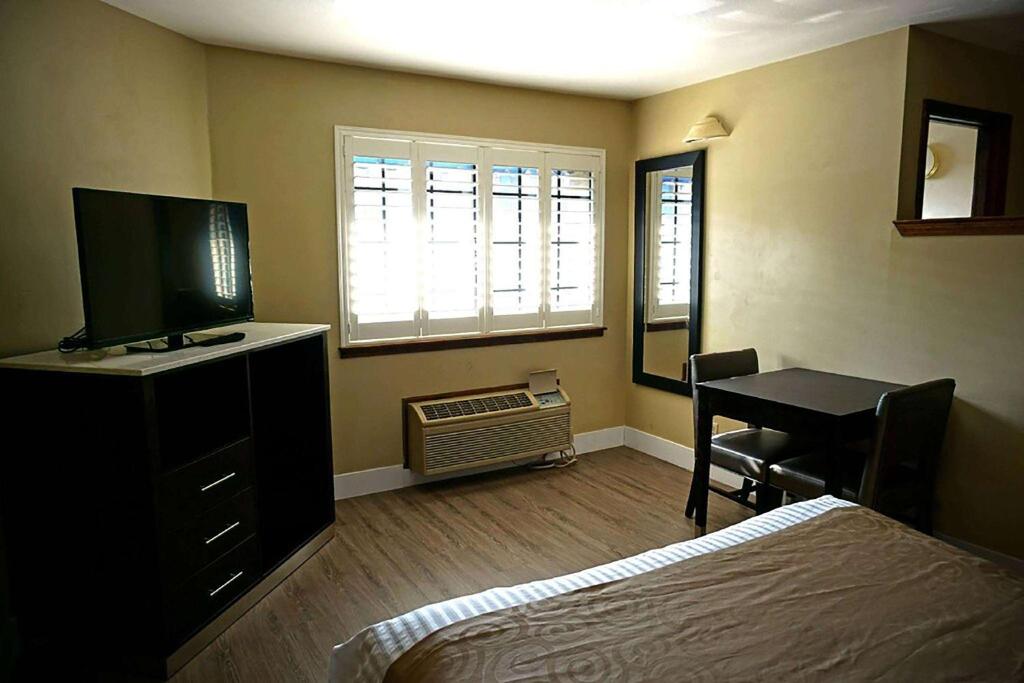 康科德Travelodge by Wyndham Concord的一间卧室配有一张床和一张带电脑的书桌