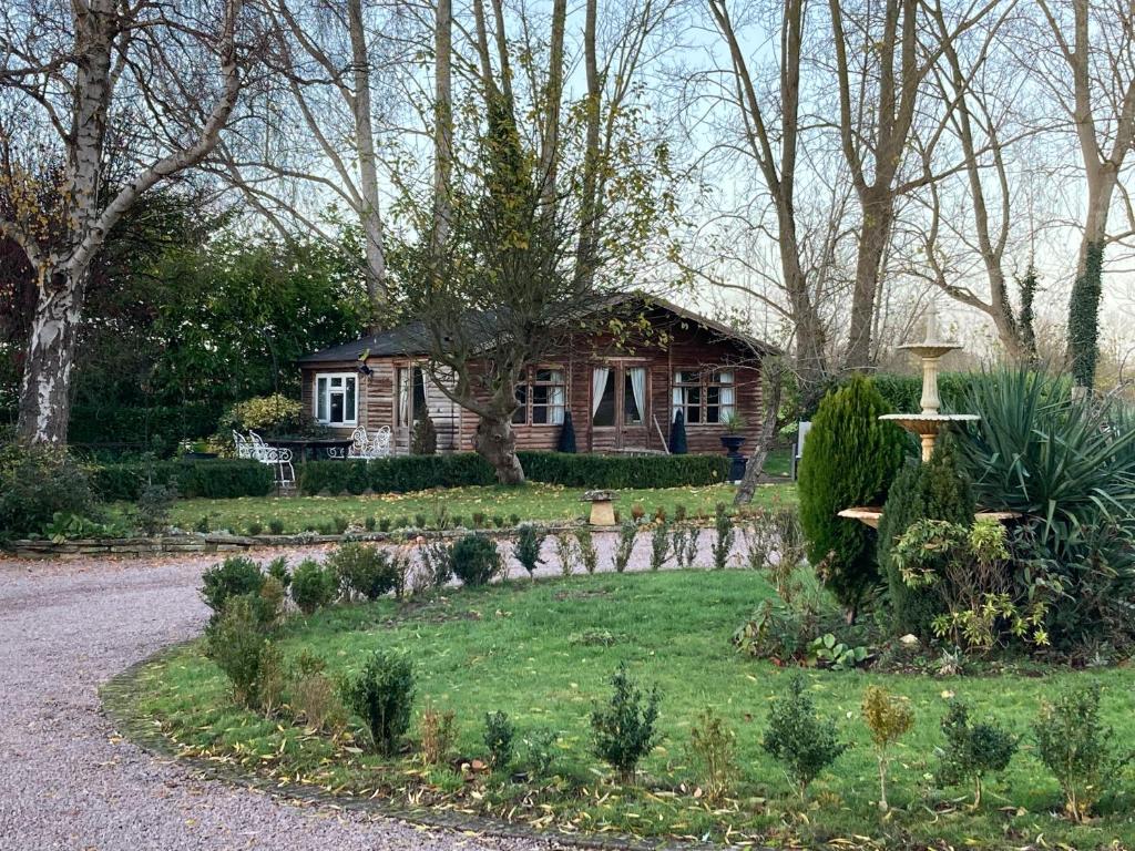 埃文河畔斯特拉特福Log Cabin, Conveniently Situated halfway between Stratford and Warwick的前面有花园的房子