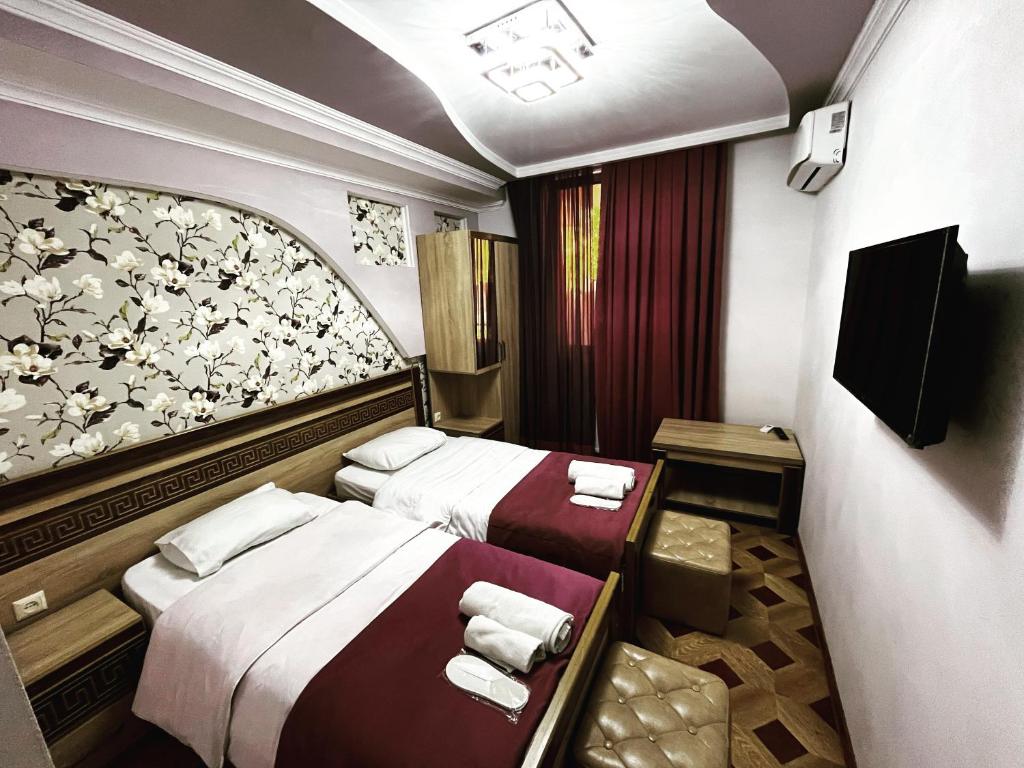库塔伊西Georgian Palace Hotel的一间酒店客房,设有两张床和电视
