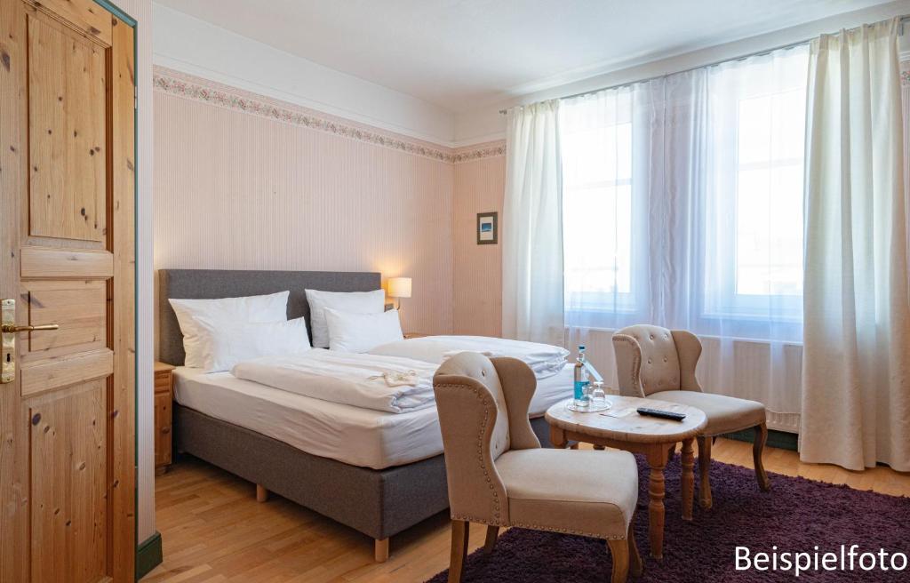 诺德奈路基尔豪斯艾姆丹麦尔酒店的酒店客房带一张床、一张桌子和椅子