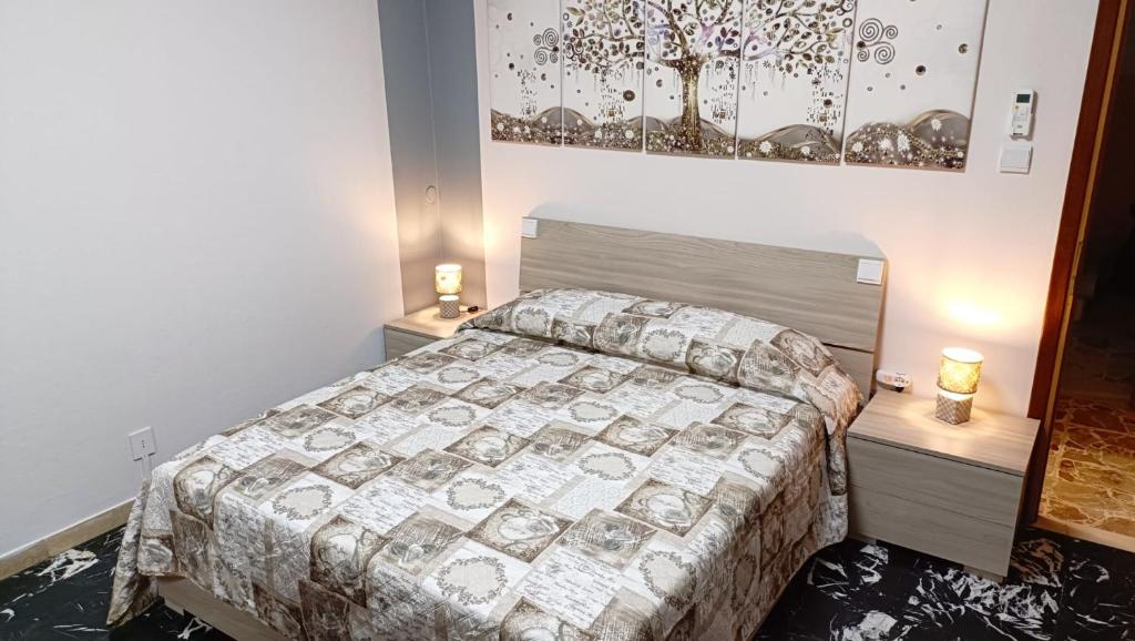 Angolo Terme20 VENTI的一间卧室配有一张床和两张带台灯的桌子。