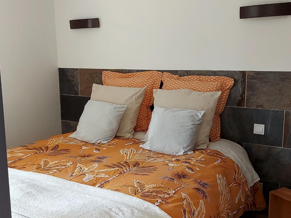 Saint-Michel-la-ForêtVilla Maëlla, studio rez-de-jardin的一张配有橙色和白色床单及枕头的床