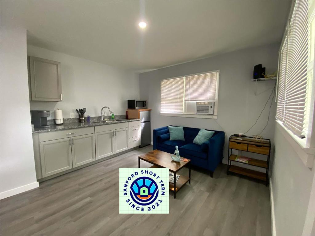 桑福德The Oasis的一间带蓝色沙发的客厅和一间厨房