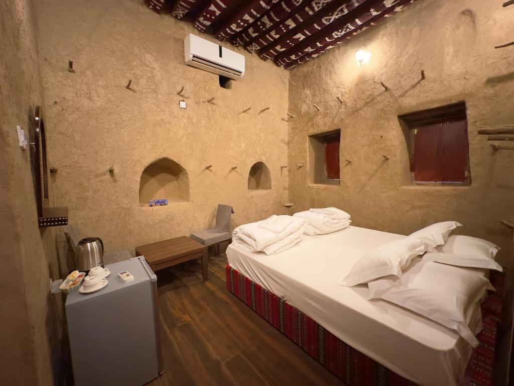 阿尔哈姆拉AL Hamra Heritage Inn的卧室配有一张石墙床