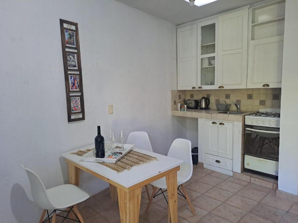 卢汉德库约Rincón Verde Chacras de Coria的厨房配有白色橱柜和桌椅