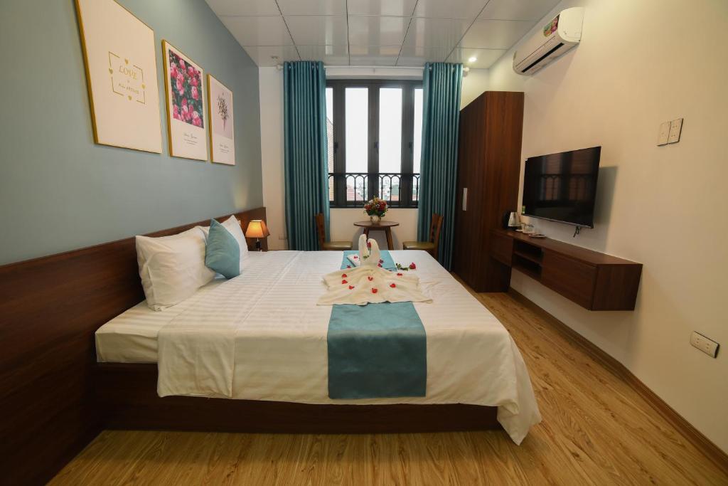 顺化AnAn Homestay Huế的酒店客房,配有一张带电视的床和一张四柱床