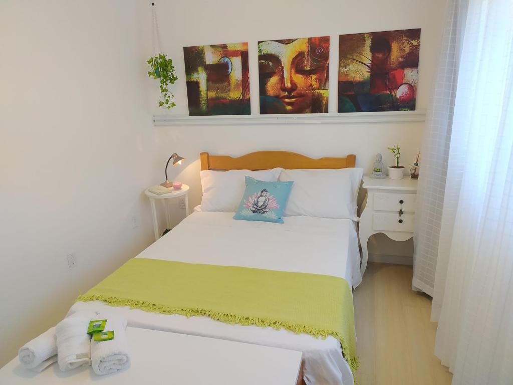 布卢梅瑙Lindo espaço inteiro Oktoberfest c/ churrasqueira.的小卧室配有一张带黄白色毯子的床