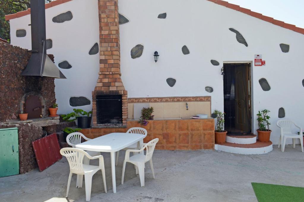 圣巴托洛梅Casa Sendero de Taidia的庭院配有桌椅和壁炉。
