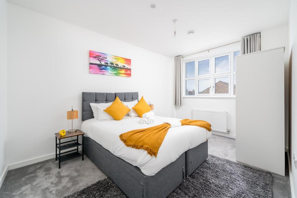 沃特福德Luxury 2 Bedroom Apartment Free Parking, Netflix, Sleeps 6的一间卧室配有一张带黄色枕头的大床