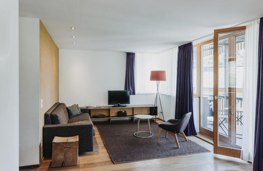 施图本阿尔贝格阿尔山洛奇酒店的客厅配有沙发和书桌及电视
