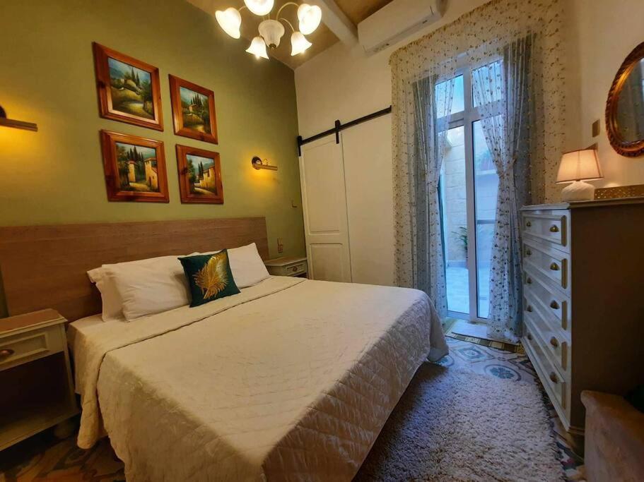 MqabbaBizzilla Lodging Suite的一间卧室配有一张床、一个梳妆台和一扇窗户。