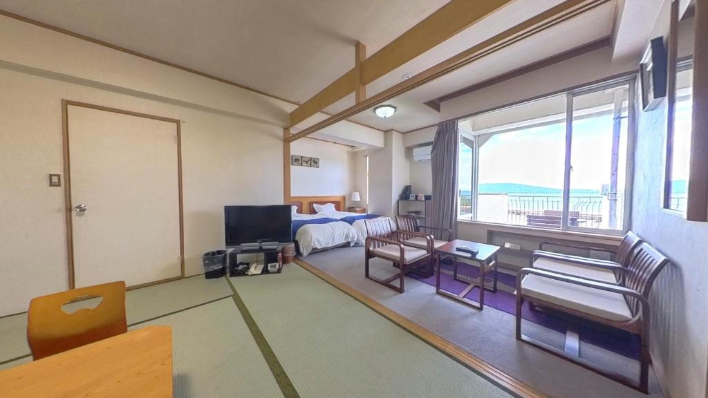 伊喜末HOTEL GREEN PLAZA SHODOSHIMA - Vacation STAY 71488v的一间带床和电视的客厅
