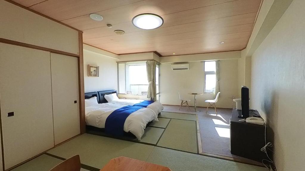 伊喜末HOTEL GREEN PLAZA SHODOSHIMA - Vacation STAY 51989v的一间卧室配有一张床和一台电视