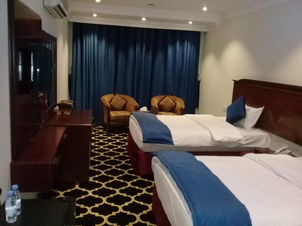 阿尔阿尔قمة البستان的酒店客房设有两张床和钢琴