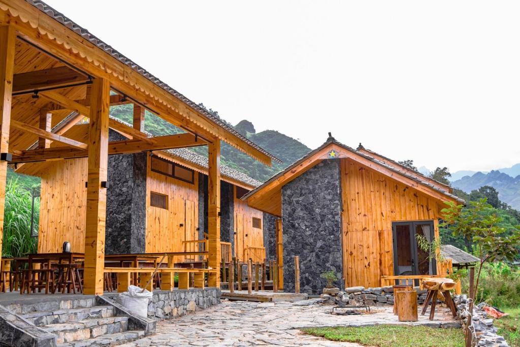 Làng CacChien's Lodge Du Gia的一座带门廊的大型木质建筑