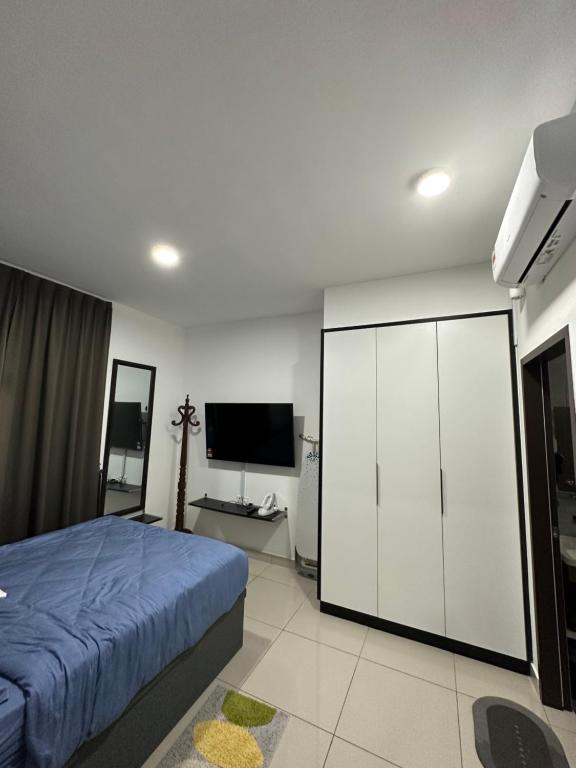 迪沙鲁Desaru Dhancell Executive Homestay All Bedrooms With NETFLIX的一间卧室配有一张床和一台平面电视