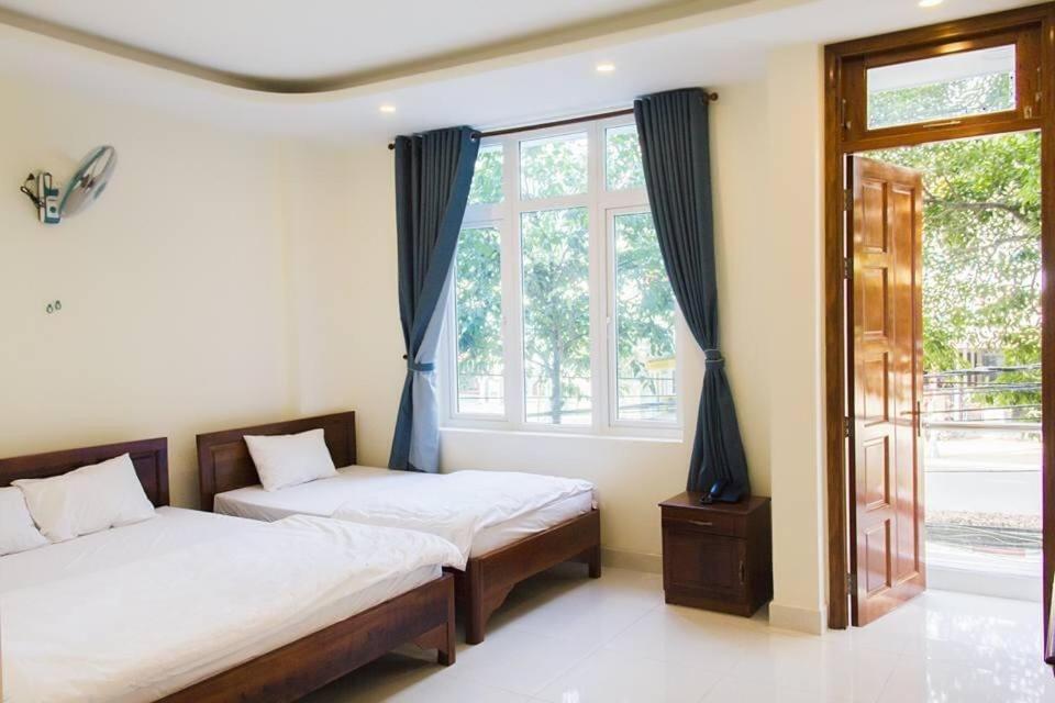 头顿Nhà Nghỉ Linh Quân 1的一间卧室设有两张床和窗户。