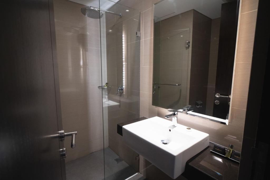 沙马林达三马林达市中心酒店的一间带水槽和玻璃淋浴的浴室