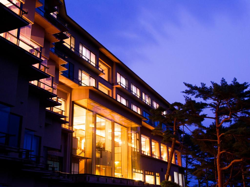 宫古市海滨净土公园酒店的一座大型建筑,晚上有很多窗户